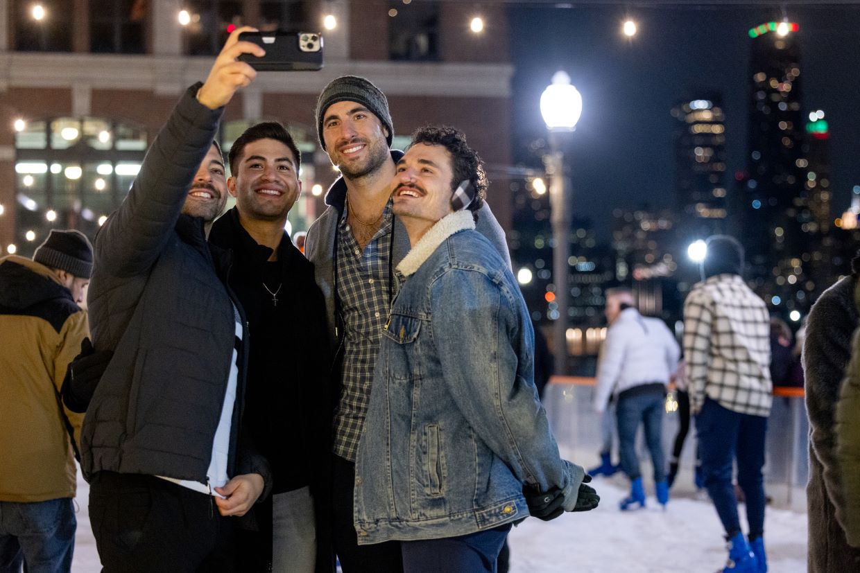 group of guys taking photo on ice rink at night