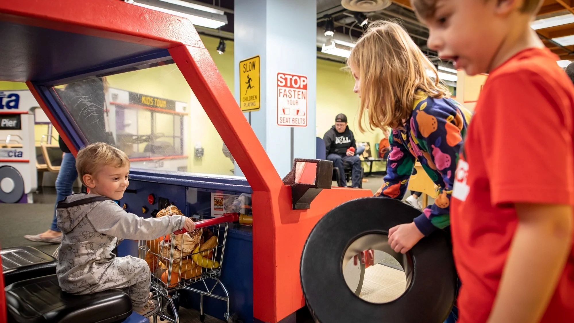 Children playing on a pretend fire truck in the Kids Town exhibit