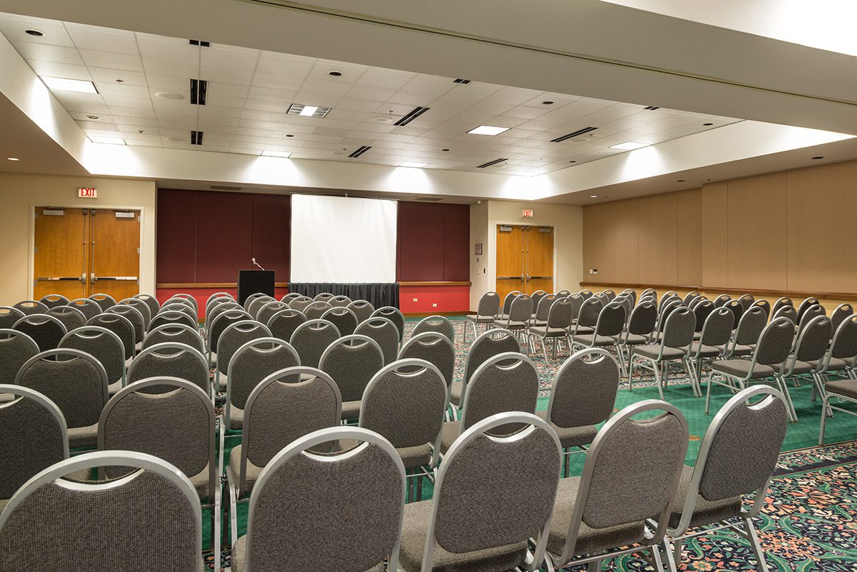 Meeting Room With Rows Of Seating, Podium And Presentation Screen