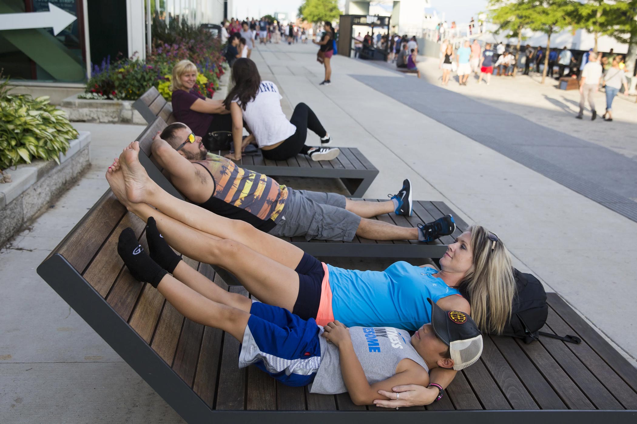 Family Relaxing On Wooden Lounge Chairs Outside at Navy Pier