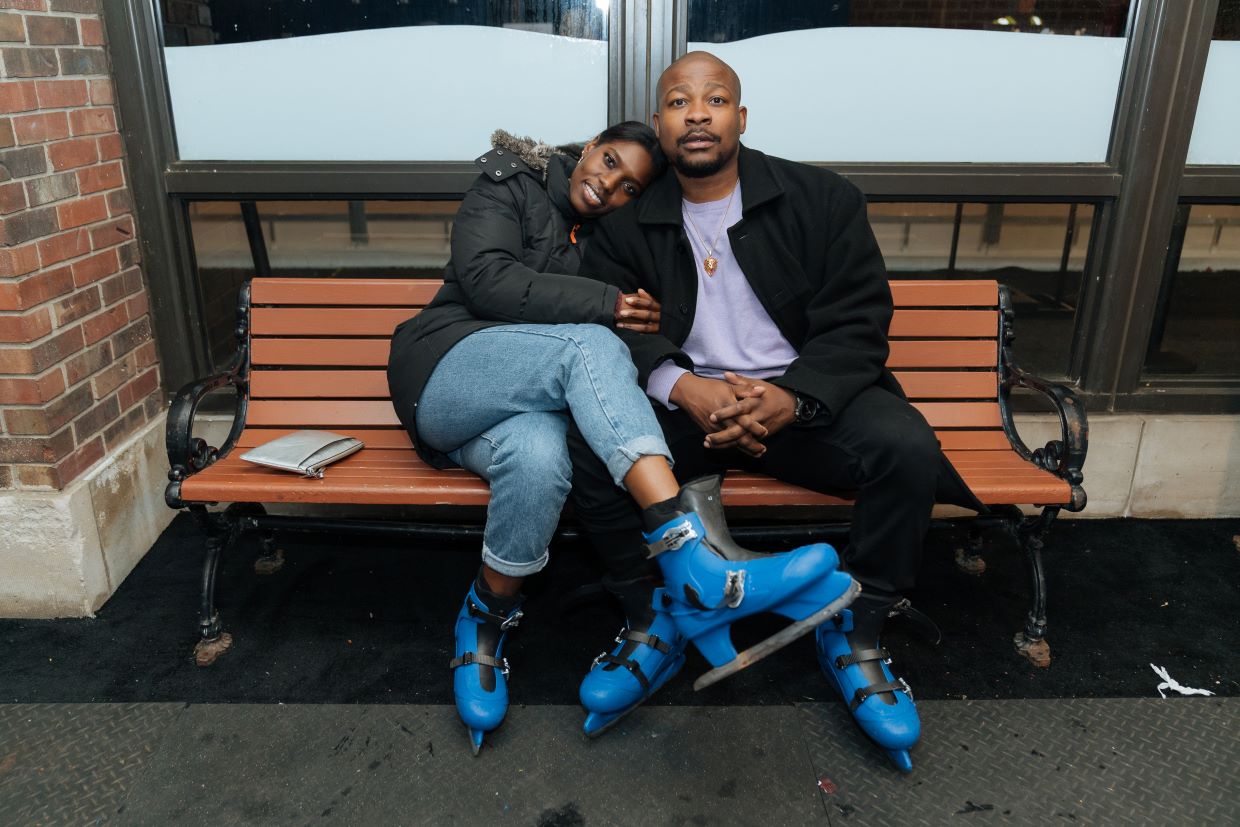 couple hugging with blue ice skates on sitting on bench