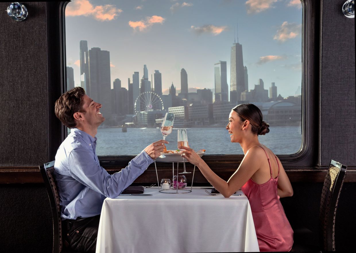A couple enjoying a dinner cruise with Navy Pier in the background.