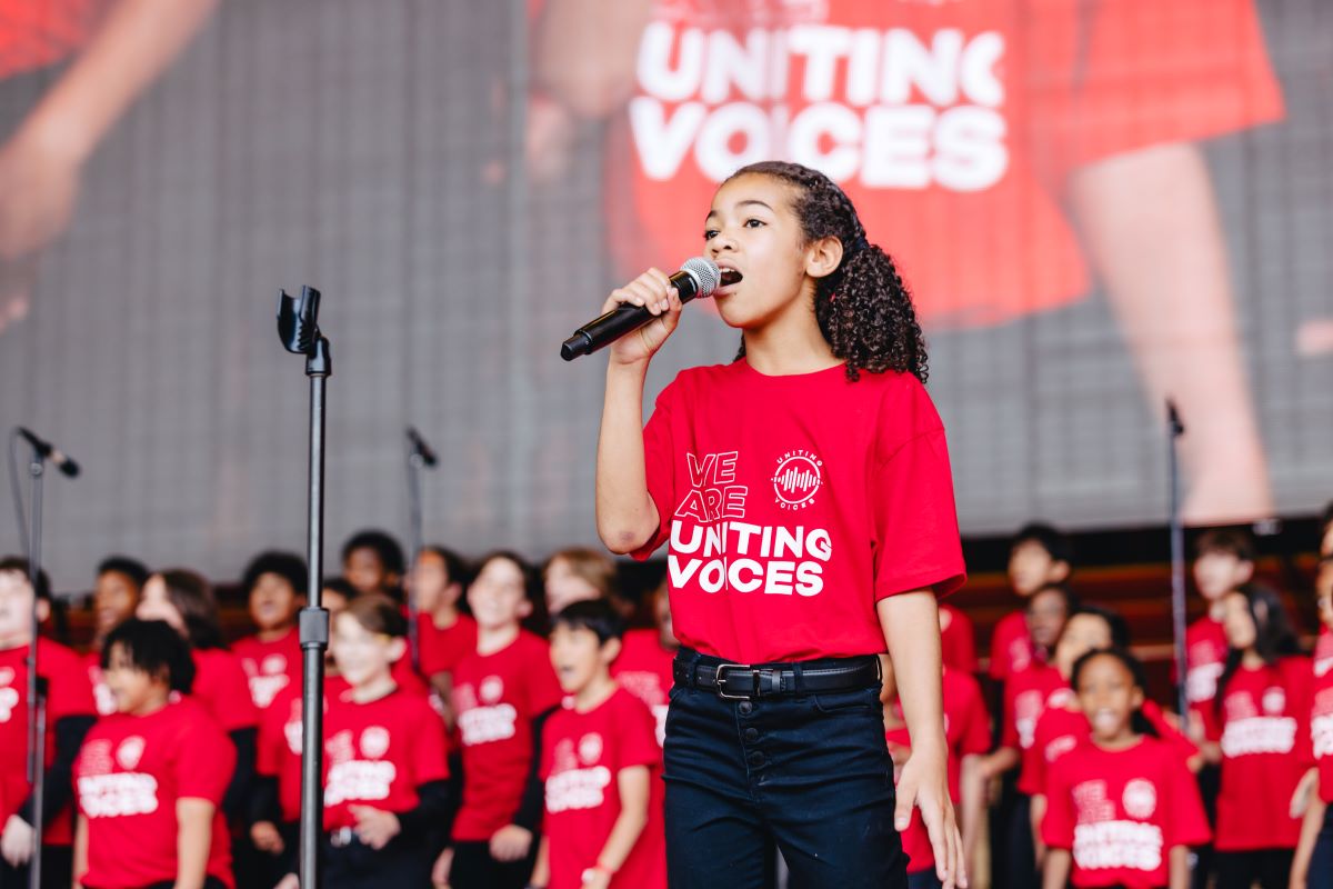 Uniting Voices Neighborhood Choir Singer on stage at Paint the Town Red 2024 web