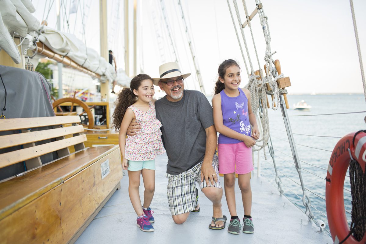 Family smiles aboard a docked sailboat at Navy Pier
