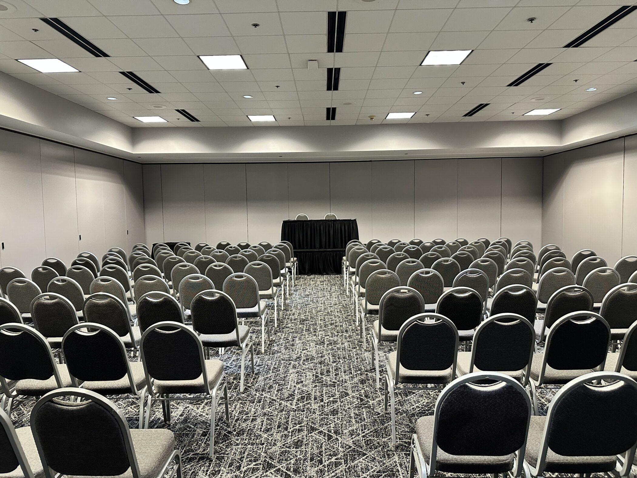 Empty meeting room with rows of chairs facing a small table at the front