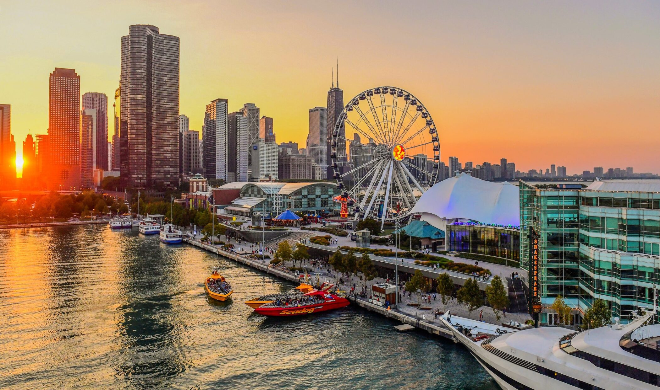 Sunset view of Navy Pier with Ferris wheel and boats on Lake Michigan