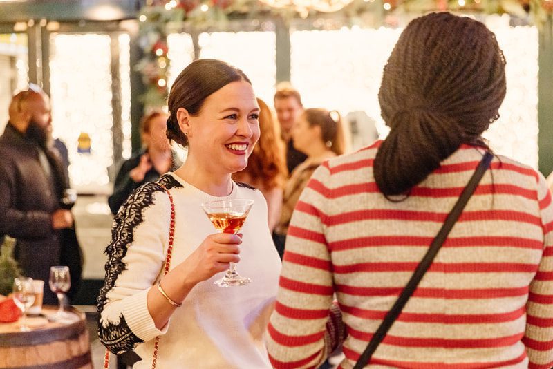 Guests holding drinks and socializing at Harry Caray’s Tavern