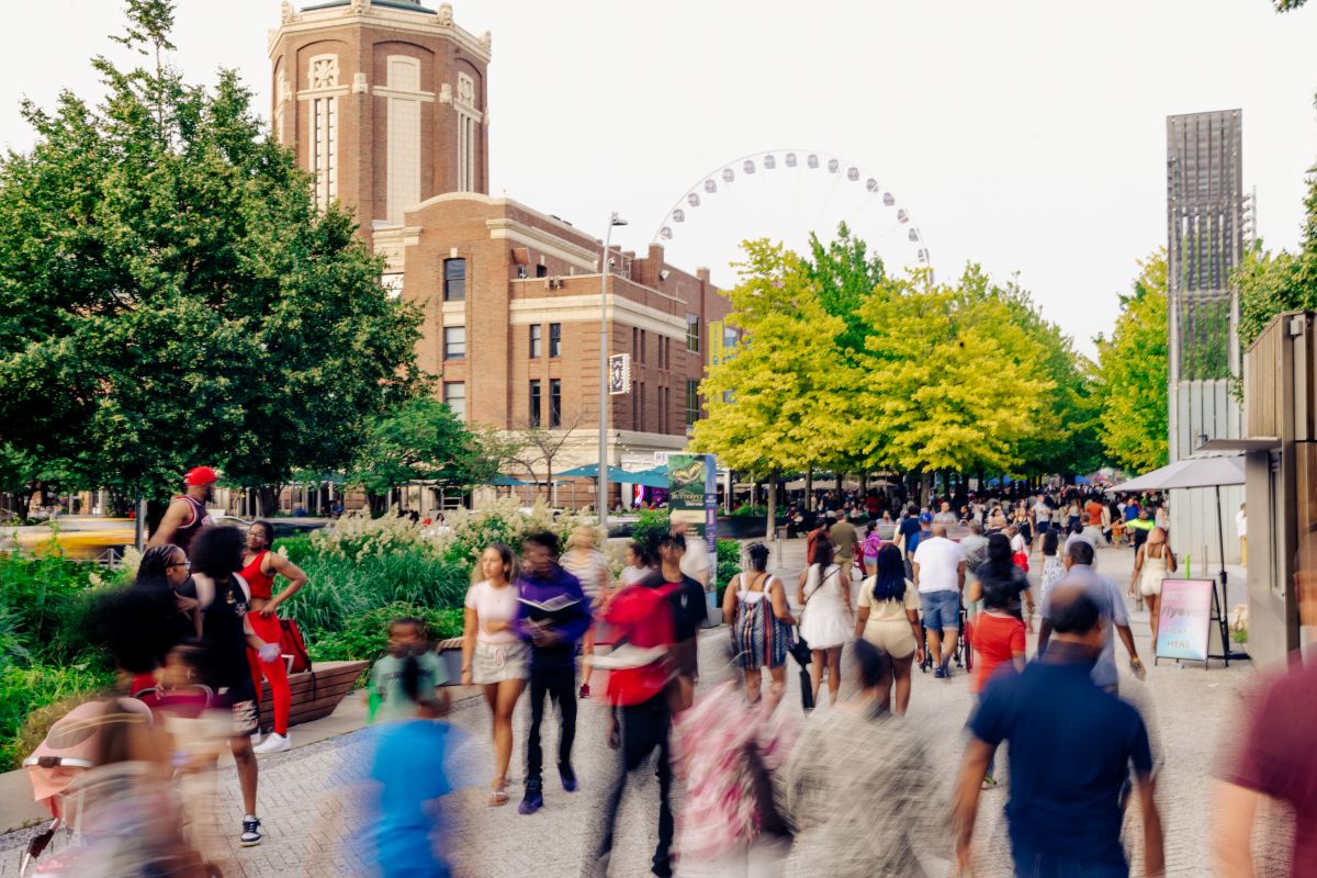 Crowd enjoying summer events at Navy Pier, Chicago with Ferris wheel in background.