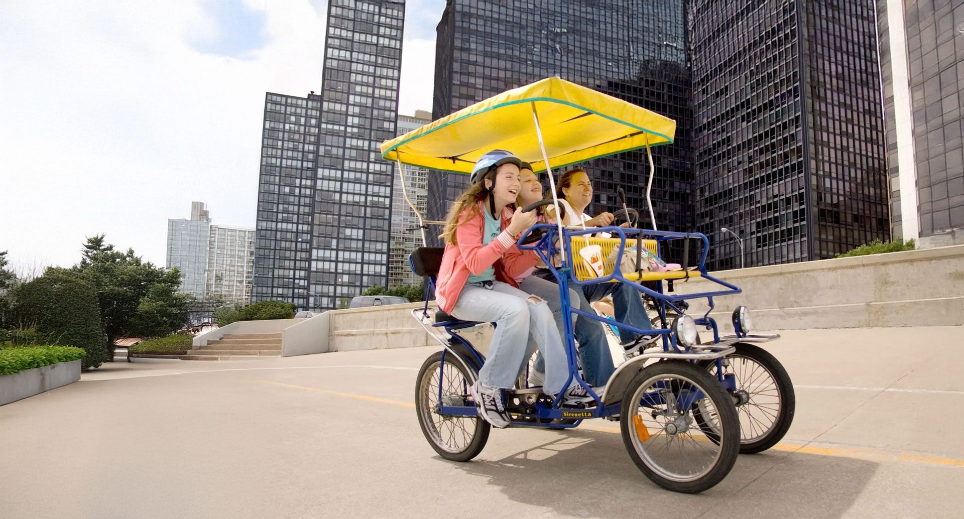 Group of people riding a surrey bike along the lakefront at Navy Pier