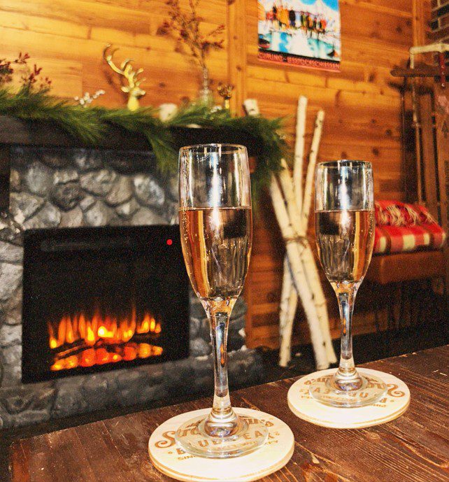 Two champagne glasses in front of a glowing fireplace at Navy Pier
