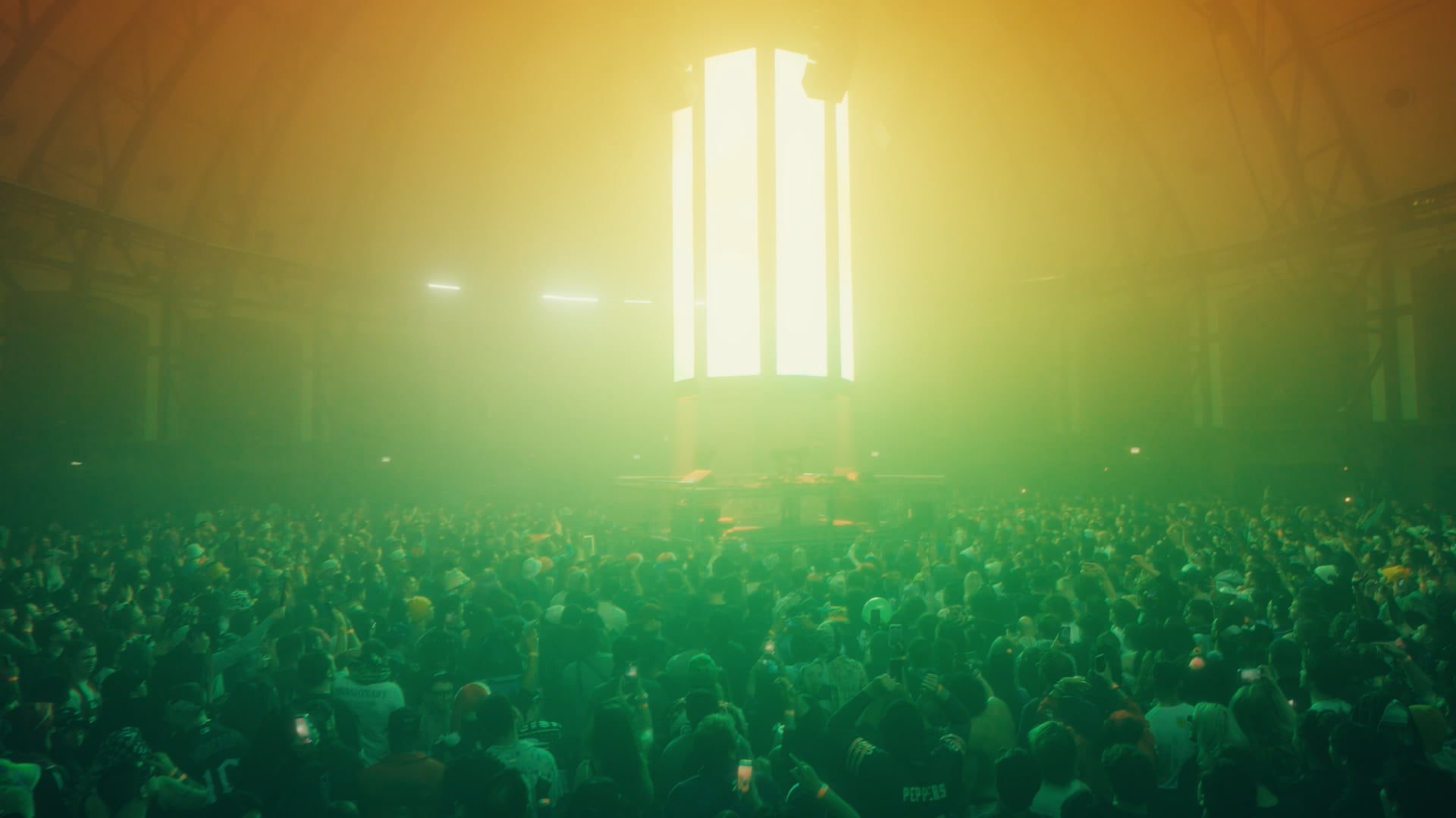 Concert crowd gathered around an illuminated pillar at Navy Pier venue