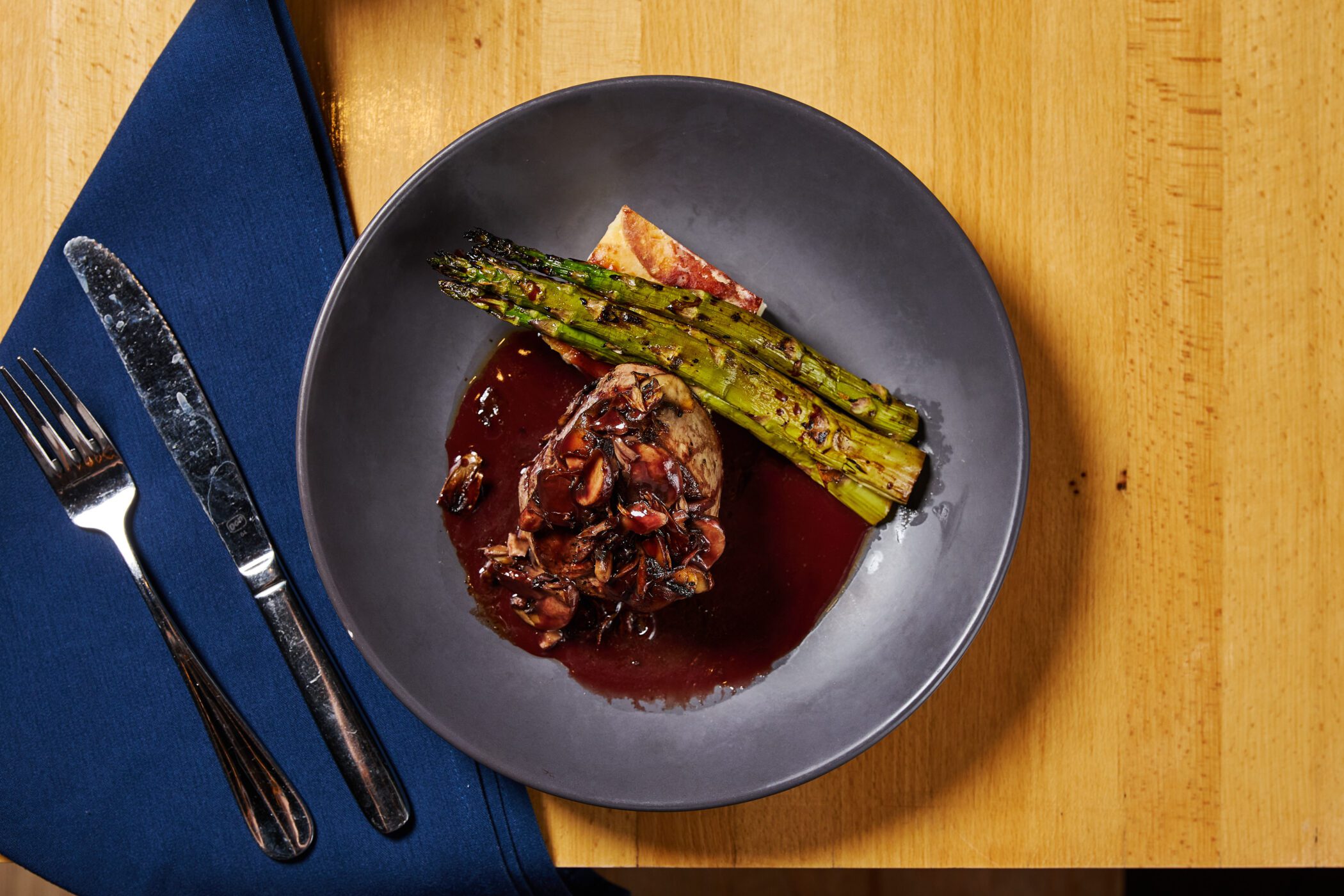 Plated filet mignon with asparagus and sauce at an Offshore restaurant dish