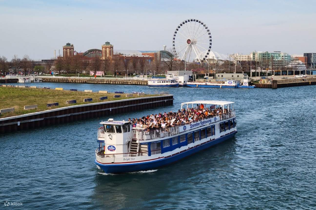 Sightseeing boat on the water near Navy Pier's Ferris wheel and Chicago skyline