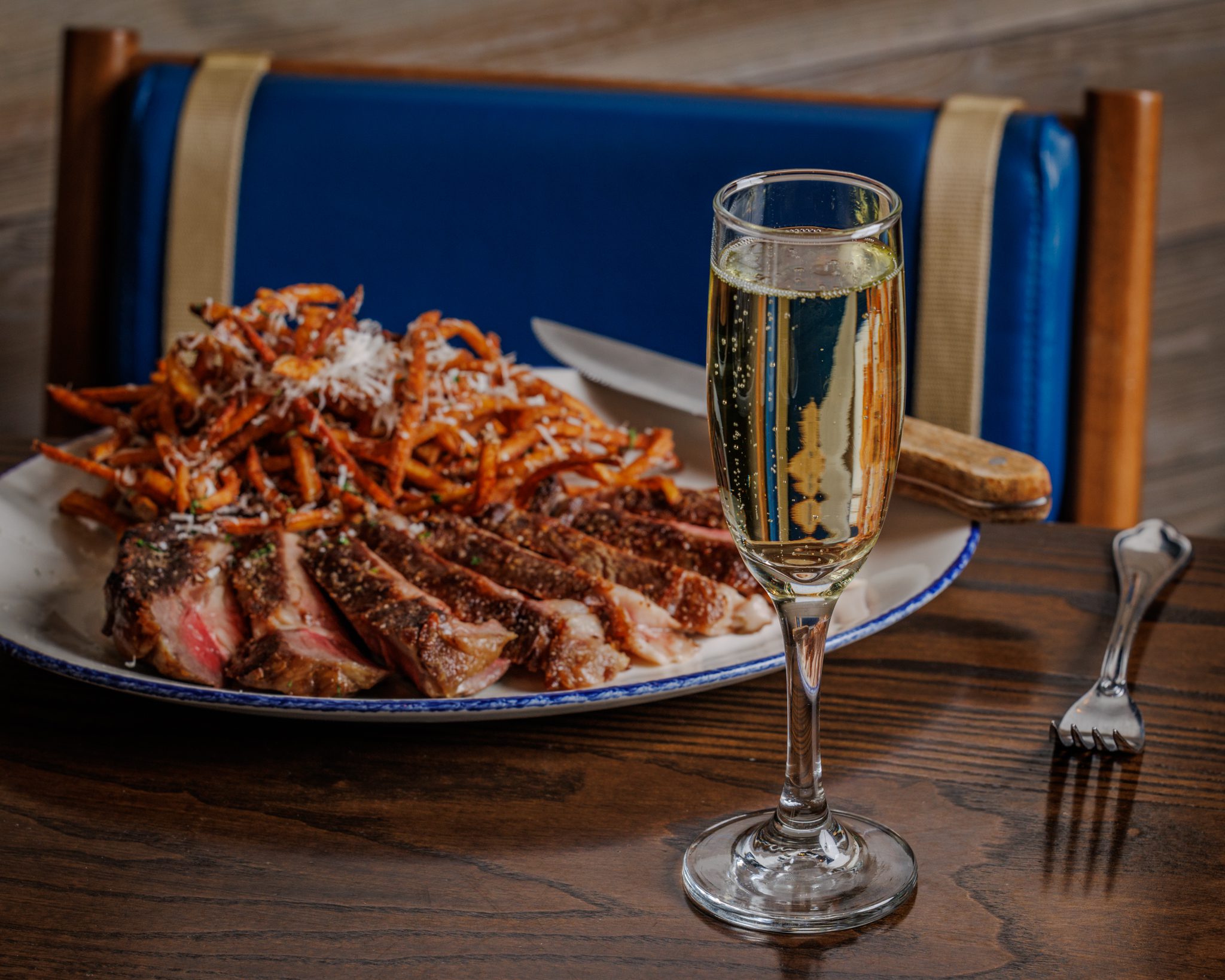 Steak and fries alongside a champagne glass at Reunion restaurant Navy Pier