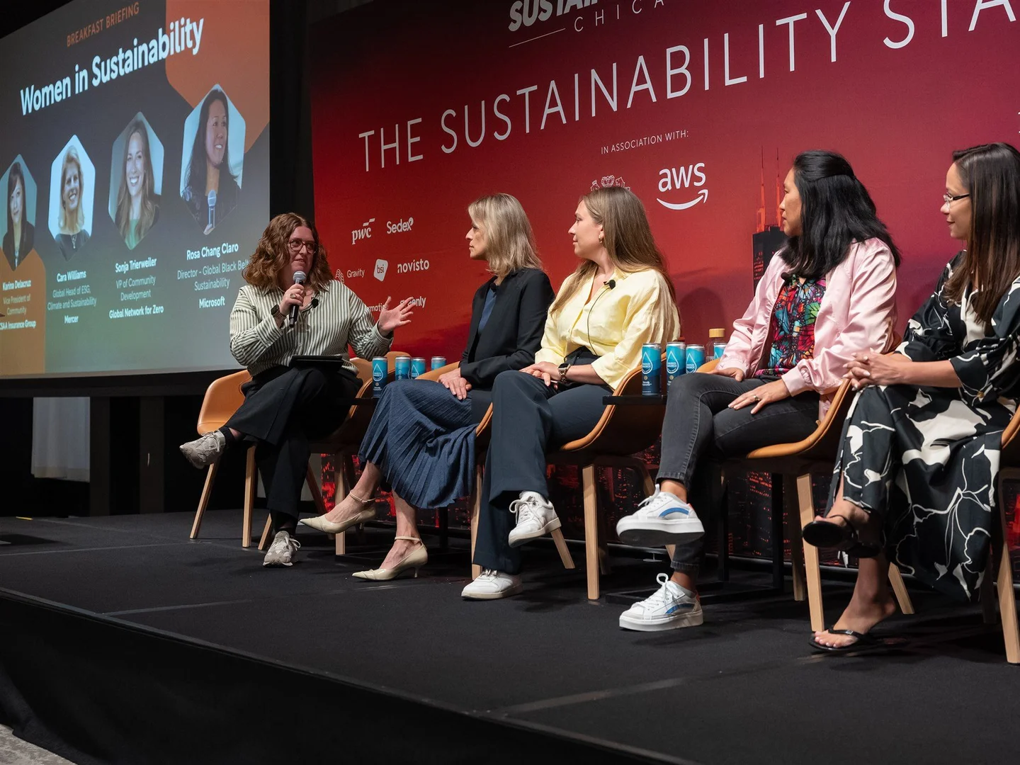 Women seated at a sustainability panel discussion during a conference