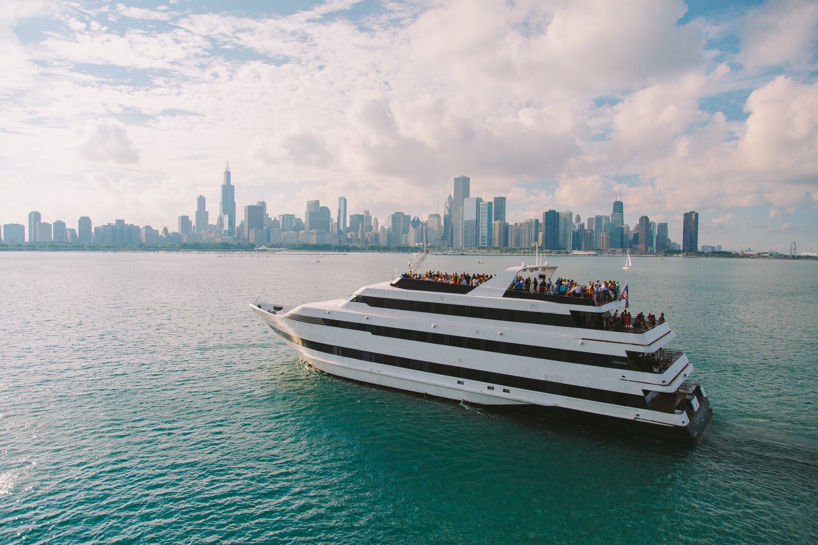 Cruise ship sailing near Navy Pier with Chicago skyline behind it
