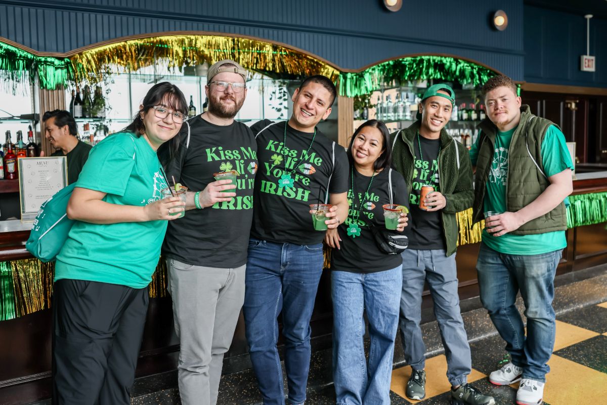 Guests in festive green attire gathered at a bar for St. Patrick's Day at Navy Pier
