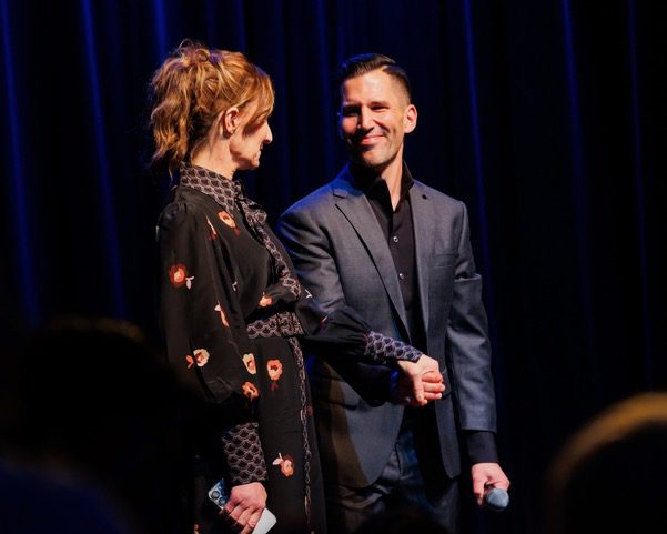 Two performers holding hands and bowing together on stage at Navy Pier