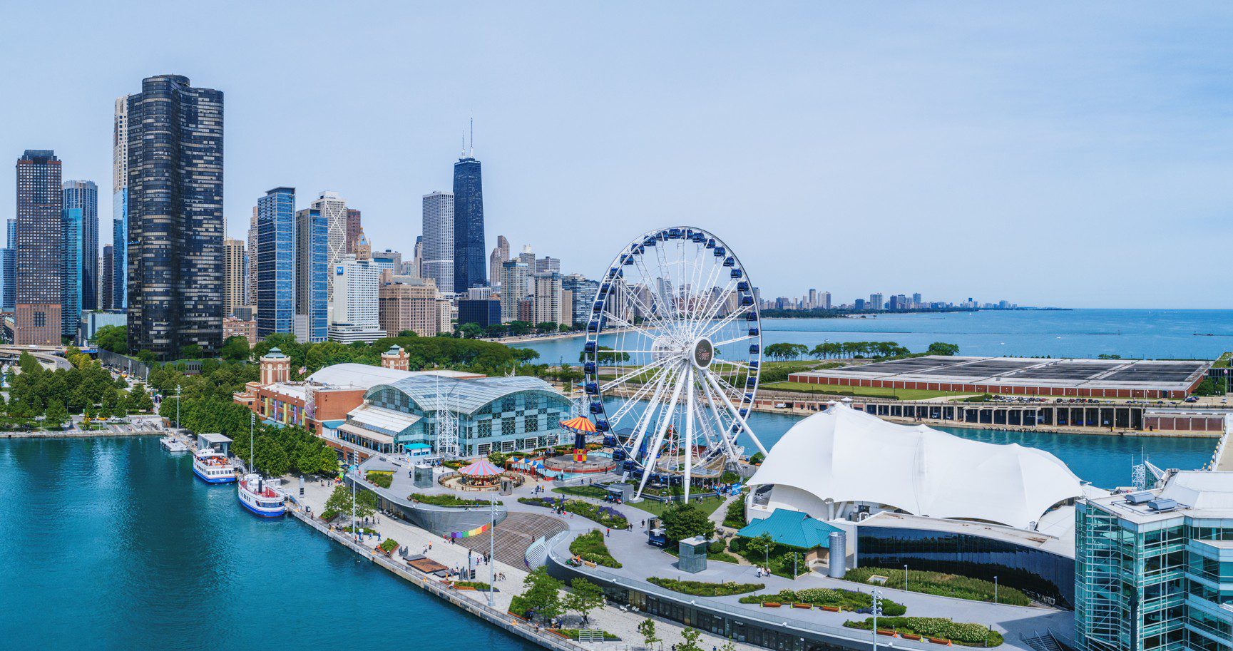 Wide aerial view of Navy Pier extending into Lake Michigan with Chicago skyline