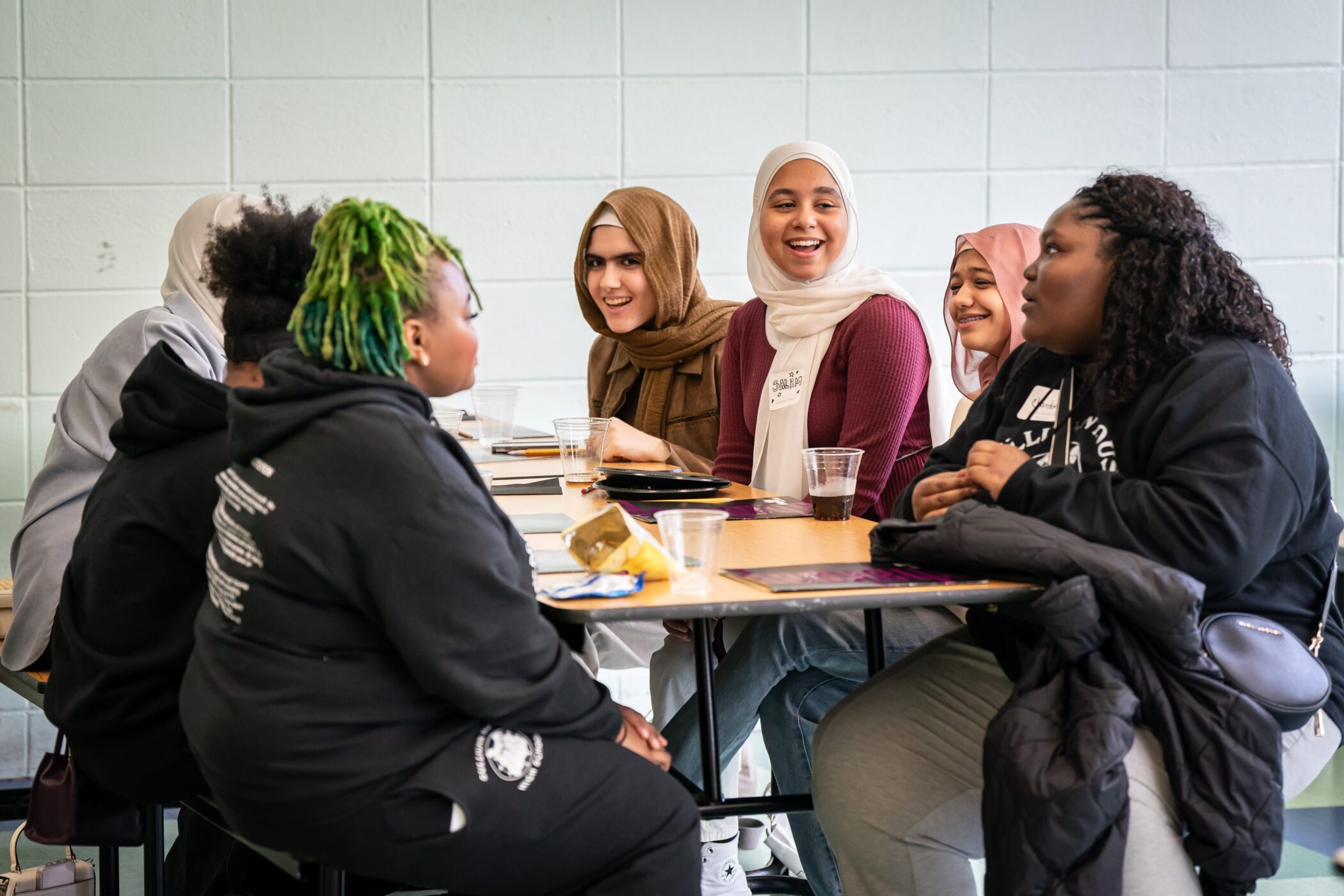 Group of young people engaged in discussion around a table at Navy Pier