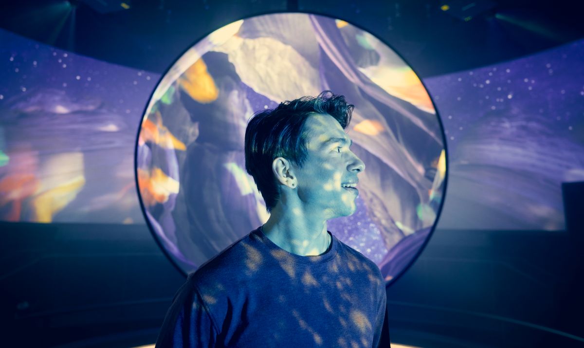 Person standing in front of an immersive digital art projection at Navy Pier