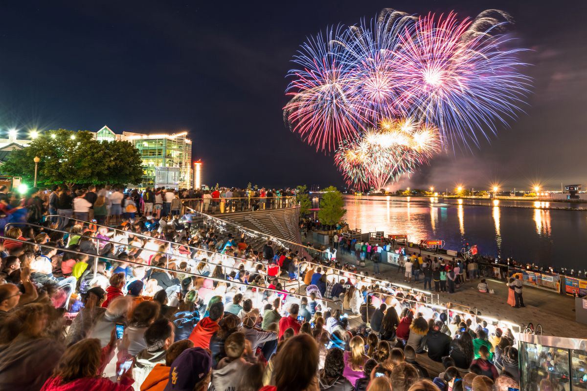 Crowd watching fireworks light up the night sky over the waterfront at Navy Pier