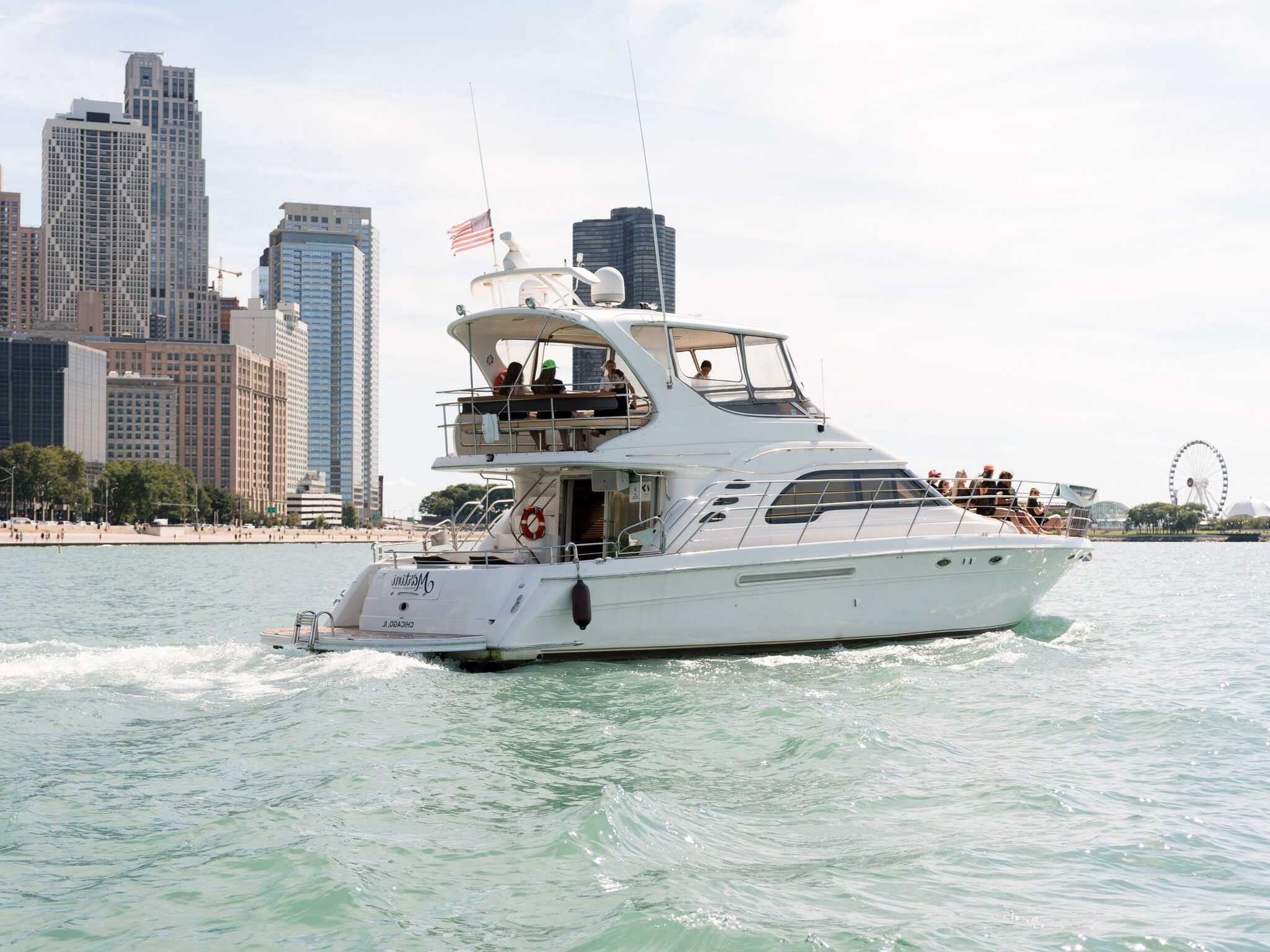 White motor yacht cruising past the Chicago skyline near Navy Pier
