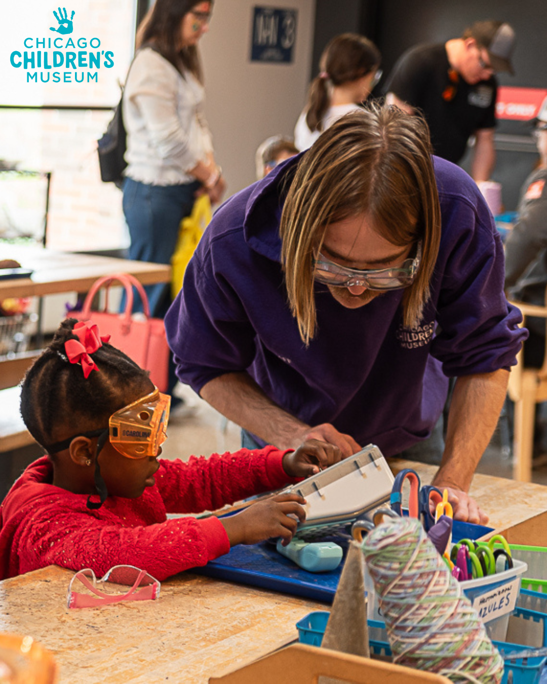 Adult helping a child with a craft at the Chicago Children's Museum