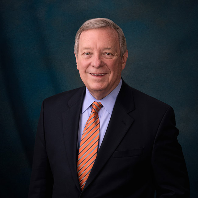 Official portrait of Senator Dick Durbin in a dark suit and orange tie